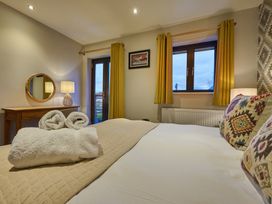 A bedroom with a bed, towels, and a mirror at Riverside Park 5 in Keswick