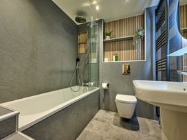 A bathroom with a bathtub, shower, toilet, and sink at Riverside Park 5 in Keswick