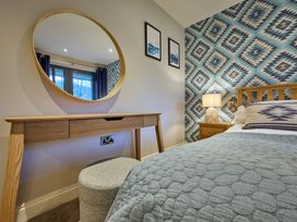 A bedroom with a bed and a dressing table at Riverside Park 5 in Keswick