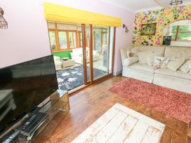 A living room with a sofa and television at The Woodlands Lower Level in Stepaside