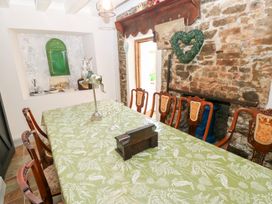 A dining room with a green tablecloth and wooden chairs at The Woodlands Lower Level in Stepaside