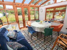 A conservatory with a table and chairs at The Woodlands Lower Level in Stepaside