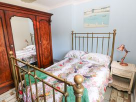 A bedroom with a metal bed and a wooden wardrobe at The Woodlands Lower Level in Stepaside
