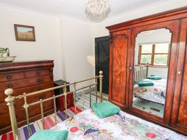 A bedroom with a bed, wardrobe, and chest of drawers at The Woodlands Lower Level in Stepaside