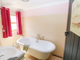 A bathroom with a bathtub and sink at The Woodlands Lower Level in Stepaside