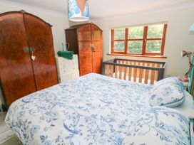 A bedroom with a bed, wardrobe, and crib at The Woodlands Lower Level, Stepaside
