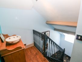 A staircase with a wash basin and wooden storage unit at The Woodlands Lower Level Stepaside