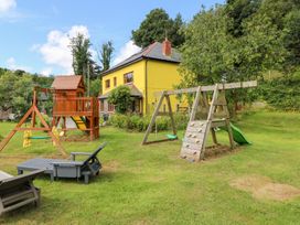 A garden with playground equipment and chairs at The Woodlands Lower Level in Stepaside