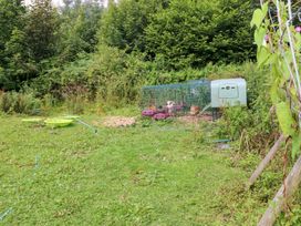 A garden area with a chicken coop and hens at The Woodlands Lower Level in Stepaside