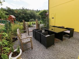 An outdoor seating area with a bench and dining table at The Woodlands Lower Level in Stepaside