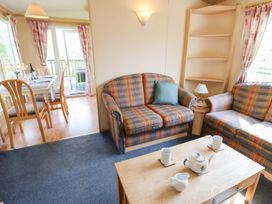 A living room with plaid sofas a coffee table and a dining table with chairs at Row End farm in Brough