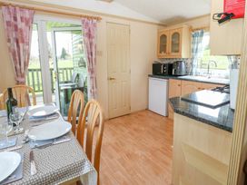 A kitchen and dining area with a table set for four people and a door leading outside at Row End farm in Brough