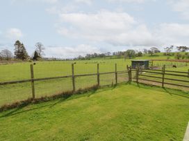 A fenced grassy field with grazing animals and a small shed at Row End farm in Brough