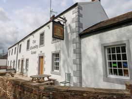 A white building with signs reading The Chamley Arms and outdoor tables and chairs at Row End farm in Brough