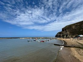 A beach with boats on water at Bethel Chapel in Staithes