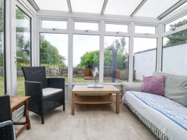 A conservatory with seating and a table at Bryn Awel in Mynytho near Abersoch
