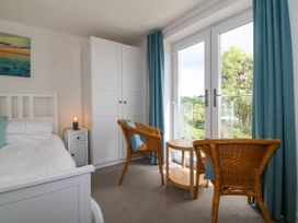 A bedroom with a bed and chairs at Bryn Awel in Mynytho near Abersoch