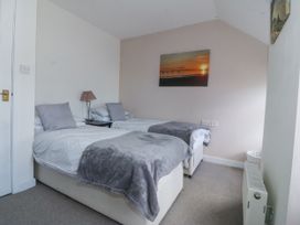 A bedroom with two beds and a painting at Bryn Awel Mynytho near Abersoch