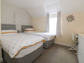 A bedroom with two beds and a desk at Bryn Awel in Mynytho near Abersoch
