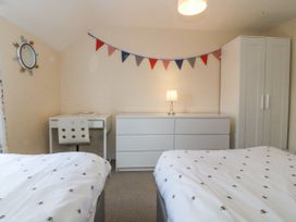 A bedroom with two beds, a desk, and a wardrobe at Bryn Awel in Mynytho near Abersoch