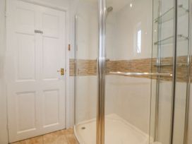 A bathroom with a shower and door at Bryn Awel in Mynytho near Abersoch
