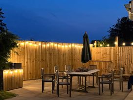 An outdoor patio with table and chairs at Gilfach in Abersoch