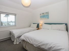 A bedroom with two beds and a window at Lane End in Abersoch