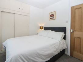 A bedroom with a bed and a wardrobe at Lane End in Abersoch