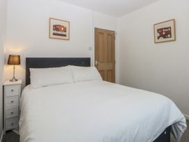 A bedroom with a bed and a lamp at Lane End in Abersoch