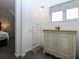 A bedroom with a cabinet and towel rack at Lane End in Abersoch