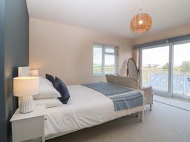 A bedroom with a bed and large window at Nyth Y Fran in Abersoch
