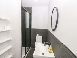 A bathroom with a shower, sink, and toilet at Nyth Y Fran in Abersoch