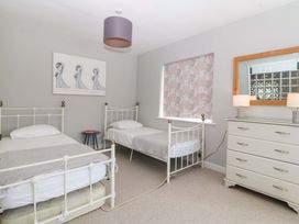 A bedroom with two single beds and a dresser at Nyth Y Fran in Abersoch