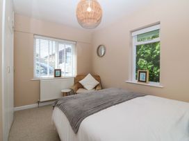 A bedroom with a bed and chair at Nyth Y Fran in Abersoch