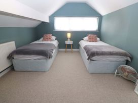 A bedroom with two beds and a lamp at Nyth Y Fran in Abersoch