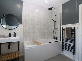 A bathroom with a bathtub and shower at Nyth Y Fran Abersoch