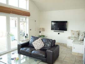 A living room with a sofa and television at Pen Y Sarn near Abersoch