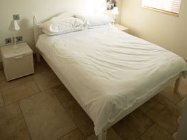 A bedroom with a bed and nightstand at Pen Y Sarn Sarn Bach near Abersoch