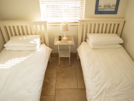 A bedroom with two single beds and a bedside table at Pen Y Sarn near Abersoch