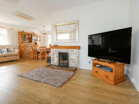 A living room with a fireplace dining table and television at Swn Y Wylan Bwlchtocyn near Abersoch