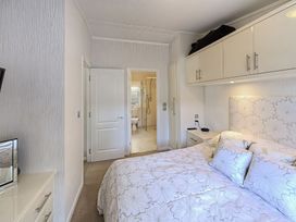 A bedroom with a bed and an ensuite bathroom at The Warren D7 in Abersoch