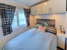 A bedroom with a bed and window at The Warren D7 Abersoch