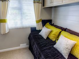 A bedroom with a sofa and cushions at The Warren D7 Abersoch