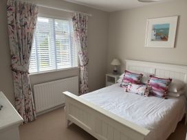 A bedroom with a bed and decorative pillows at Ty Coed Abersoch