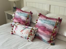 A bedroom with decorative pillows on a bed at Ty Coed in Abersoch