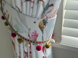 A colorful curtain with pom-pom trim at Ty Coed Abersoch