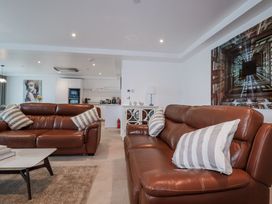 A living room with leather sofas and a coffee table at 13 Cliff Edge in Newquay
