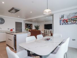 An open plan living area with a dining table and kitchen at 13 Cliff Edge in Newquay