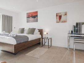 A bedroom with a bed, nightstand, and vanity at 13 Cliff Edge in Newquay