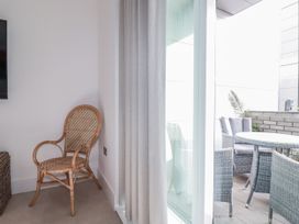 A balcony with a chair and table at 13 Cliff Edge in Newquay